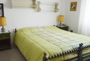 een slaapkamer met een bed met een groen dekbed bij L'alloggio di Anna Maria. Camera con bagno privato in Empoli