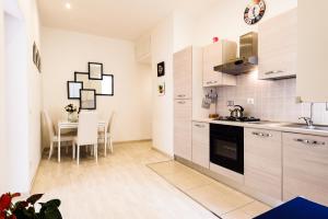 a kitchen with white cabinets and a dining table at Saint Peter Cozy Apartment in Rome