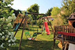 a playground with a slide and swings in a yard at Gites le Pimayon in Manosque