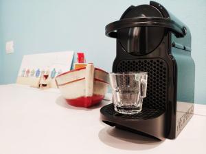 a coffee maker with a glass on a counter at La Dolce Cagliari holiday home in Cagliari