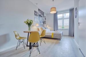 sypialnia z łóżkiem, stołem i krzesłami w obiekcie FLORIANSKA 32 by PI Apartments w Krakowie