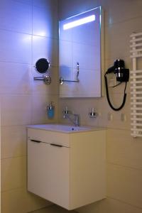 ein Bad mit einem Waschbecken und einem Spiegel in der Unterkunft MeDoRa Park - Hotel MeDoRa*** in Gárdony