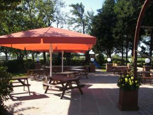 a group of picnic tables with a large umbrella at The Treebridge Hotel in Nunthorpe