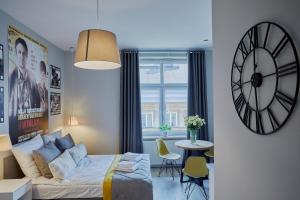 sypialnia z łóżkiem i zegarem na ścianie w obiekcie FLORIANSKA 32 by PI Apartments w Krakowie