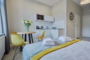 sypialnia z łóżkiem, stołem i krzesłami w obiekcie FLORIANSKA 32 by PI Apartments w Krakowie