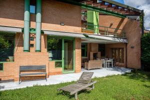 eine Terrasse mit zwei Stühlen und einer Rasenbank in der Unterkunft Villa delle Ortensie in Tavagnacco