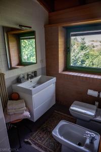 ein Bad mit einem Waschbecken, einem WC und einem Fenster in der Unterkunft Villa delle Ortensie in Tavagnacco