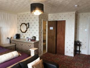 Un dormitorio con una cama, un sofá y un espejo. en Cherry Blossom Inn, en Blackpool 90 fotos más