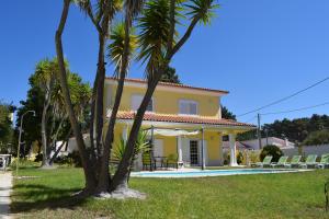 a villa with a swimming pool and palm trees at B House Verdizela in Corroios