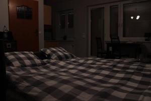 1 cama con manta a cuadros en un dormitorio en Mieszkanie na uboczu Dobrzeń Wielki, en Dobrzeń Wielki