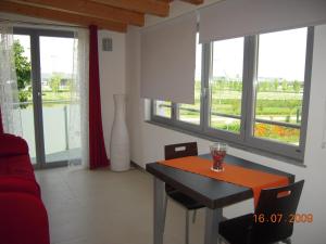 a living room with a table and chairs and windows at BE HOME Fiera in Pero