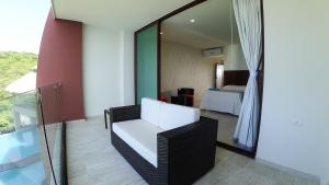 Habitación de hotel con balcón, cama y espejo. en Pacific King Hotel en Cuatunalco