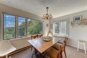 a dining room with a table and chairs and windows at Snowside 22 in Waitsfield