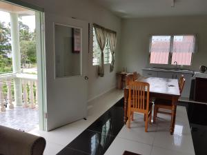 a kitchen with a table and chairs and a dining room at Malau Lodge in Nuku‘alofa