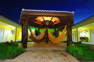 a wooden pergola with curtains on a house at Pousada Villa Real in Areia