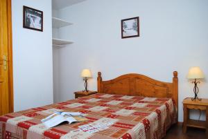 una camera con un letto con una coperta rossa e bianca di Résidence Néméa Le Hameau de Balestas a Germ