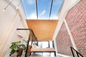 a loft with a large window and a brick wall at OwlStay Jiufen Wander in Jiufen