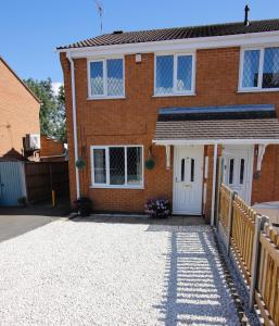 a brick house with white doors and a driveway at Hinckley Home Sleeps 5 Complete House in Leicester