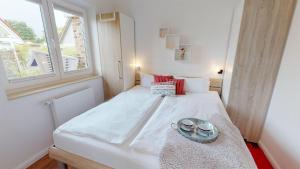 ペルツァーハケンにあるFeriendorf Südstrand Haus 51の小さなベッドルーム(白いベッド1台、窓付)