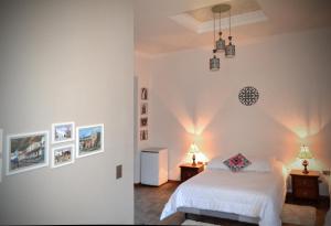 ein Schlafzimmer mit einem weißen Bett und zwei Tischen mit Lampen in der Unterkunft TRAVELER'S HOUSE QUITO in Quito