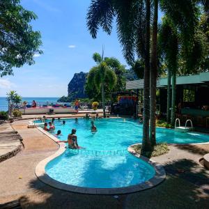 a group of people in a swimming pool near the ocean at Blanco Hideout Railay - Youth Hostel 18 to 35 Only in Railay Beach