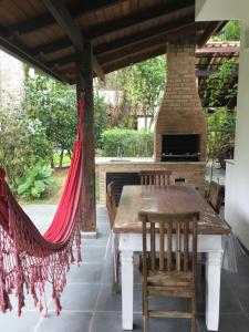 un patio con mesa, sillas y chimenea en Condominio Frente Praia Boissucanga en Boicucanga