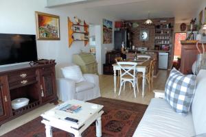 a living room with a white couch and a table at Shells Cozy on-the-beach Hideaway in Sheffield Beach