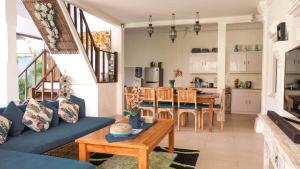 ein Wohnzimmer mit einer blauen Couch und einem Tisch in der Unterkunft Villa Alam Biru Gardenia in Seminyak