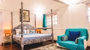 ein Schlafzimmer mit einem Himmelbett und einem blauen Stuhl in der Unterkunft Villa Alam Biru Gardenia in Seminyak + 32 Fotos