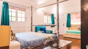 Schlafzimmer mit Himmelbett und blauen Vorhängen in der Unterkunft Villa Alam Biru Gardenia in Seminyak