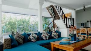ein blaues Sofa im Wohnzimmer mit einem Tisch in der Unterkunft Villa Alam Biru Gardenia in Seminyak