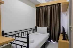 ein Schlafzimmer mit Bett, Schreibtisch und Fenster in der Unterkunft Minimalist 1BR at Akasa Pure Living Apartment By Travelio in Ciater-hilir + 8 Fotos