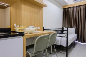 ein Zimmer mit einem Bett und einem Tisch und Stühlen in der Unterkunft Minimalist 1BR at Akasa Pure Living Apartment By Travelio in Ciater-hilir