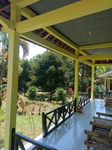 a covered porch with benches and a view of a garden at Bukit Senaru Homestay in Senaru +76 photos
