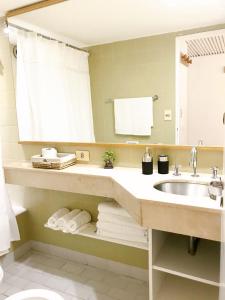 ein Badezimmer mit einem Waschbecken, einem Spiegel und Handtüchern in der Unterkunft Corazón de Buenos Aires in Buenos Aires