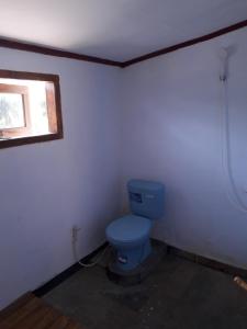 a bathroom with a blue toilet and a window at Crispycool Homestay in Kuta Lombok