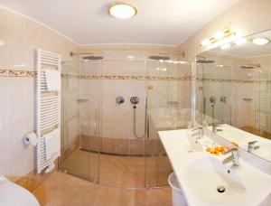 La salle de bains est pourvue d'une douche, de 2 lavabos et d'une cabine de douche. dans l'établissement Sporthotel Kalcherhof, à Racines