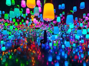 a person sitting in a chair in a room with colorful lights at Mifuneyama Rakuen Hotel in Takeo