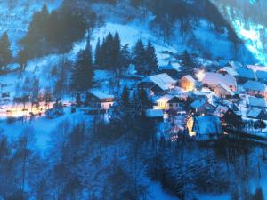Un petit village dans la neige la nuit dans l'établissement Maison independante de montagne en ALSACE, à Bellefosse