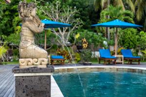 a fountain with a statue next to a pool at Pondok Baruna Frangipani in Nusa Lembongan
