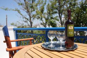 Una botella de vino y dos copas en una mesa. en Katerina Babis Studios, en Agios Prokopios