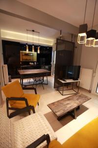 a living room with couches and tables and a television at Yellow Black Magic in Thessaloniki