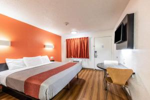 a hotel room with a bed and a table at Motel 6-North Richland Hills, TX in North Richland Hills