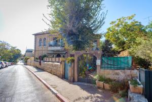 an old brick building with a gate on a street at Colony Suites - Hildesheimer St. in Jerusalem