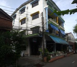 a tall white building with lots of windows at Residence House in Trat