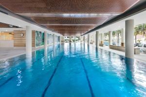 - une piscine d'eau bleue dans un bâtiment dans l'établissement Meriton Suites Waterloo, à Sydney