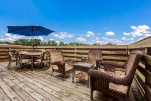 a deck with a table and chairs and an umbrella at Quality Inn in Clare