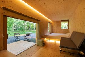 una habitación con un sofá y una cama y una mesa en Snow Peak Jyubako（AKAIGAWA TOMO PLAYPARK）, en Akaigawa