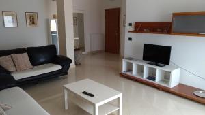 ein Wohnzimmer mit einem Sofa und einem Flachbild-TV in der Unterkunft Casa Cristina in Chioggia