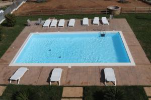 - une vue sur la piscine et ses chaises longues dans l'établissement LE TORRI DEL CILENTO, à Santa Maria di Castellabate
